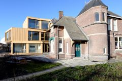 Het ‘Familie de Boer huis’ met op de achtergrond het nieuwe appartementengebouw