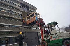 Naar binnen hijsen van CT-scanner en positioneringsrobot in het protonentherapiecentrum